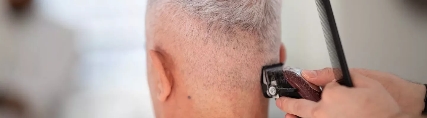 person using hair razor on man s hair